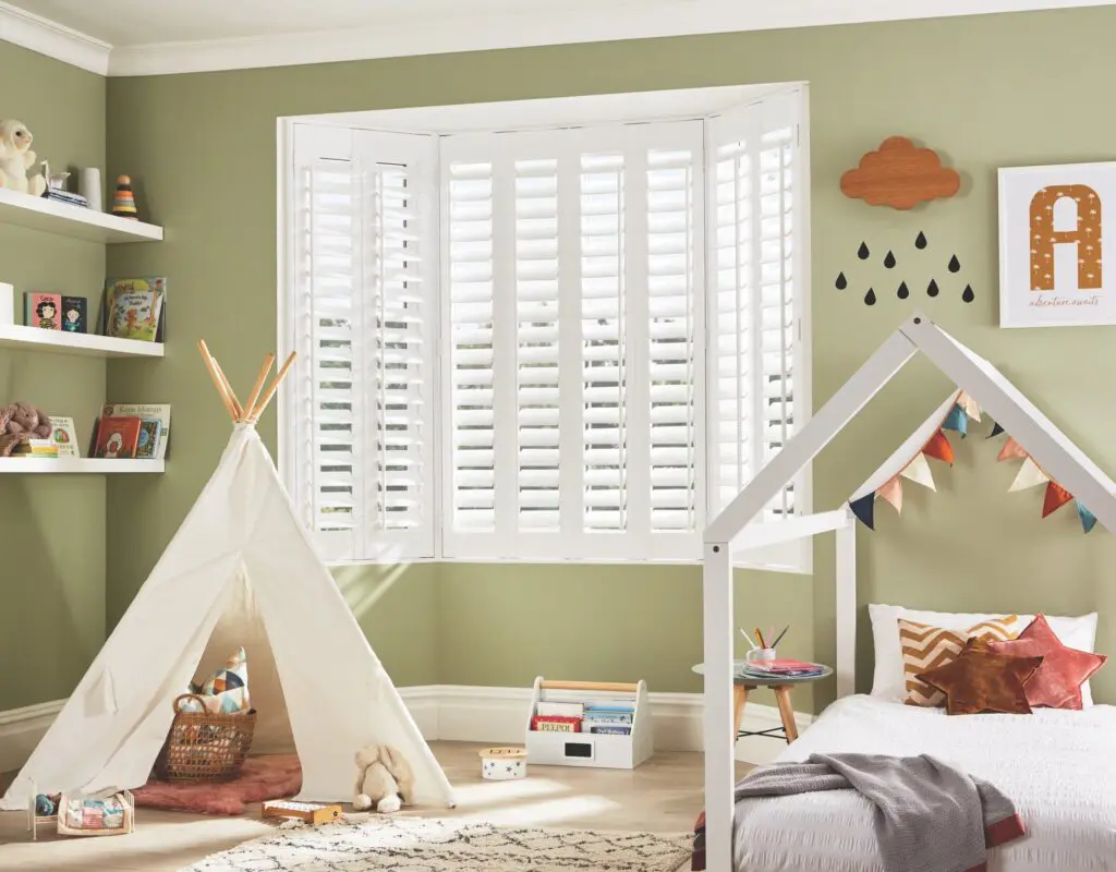 Cotton-coloured full height plantation shutters fitted in a bay window bedroom