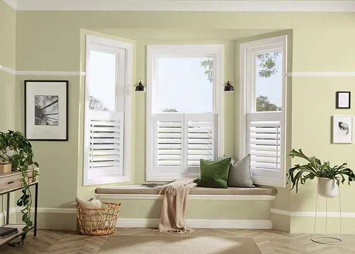 Cafe style shutters covering the lower half of a living room window