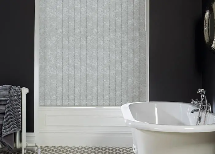 Light grey vertical blind louvers fitted across a large window